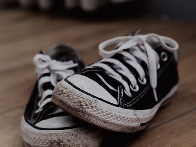 Close-up of a pair of sneakers on a wooden floor.